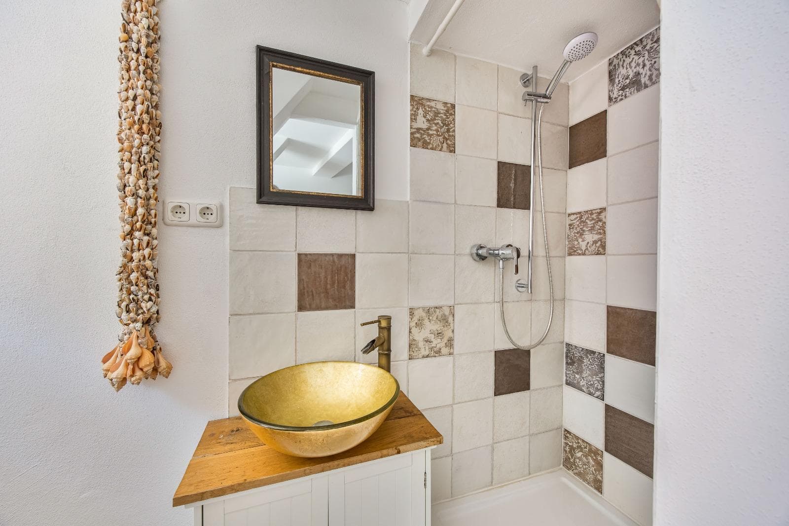Guest bathroom with golden basin and mosaic shower in the Punkt XII wellness area