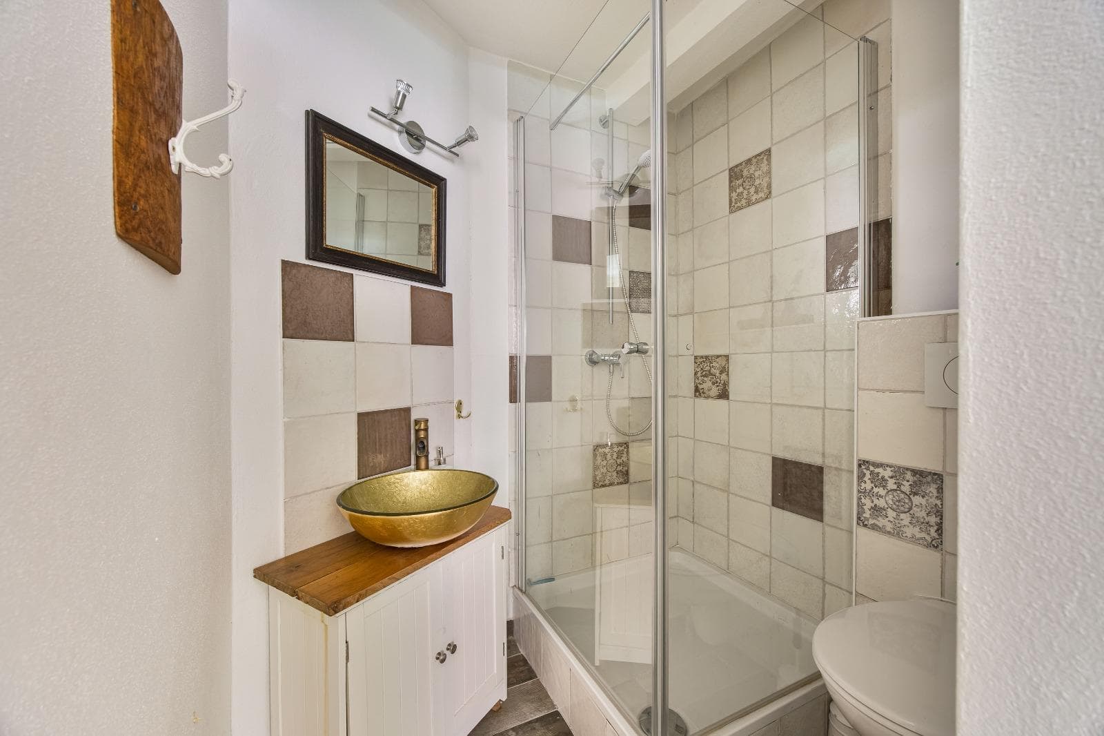 Modernes Bad mit Mosaikakzenten und goldener Waschschale