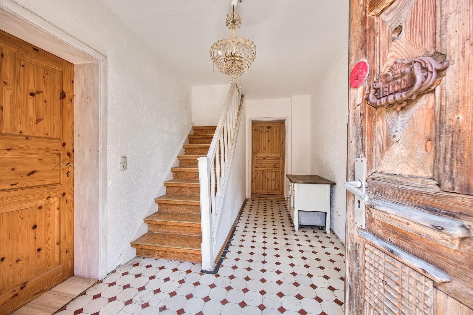 Entrance hall with chandeliers, Buddha reliefs and a natural-stone floor
