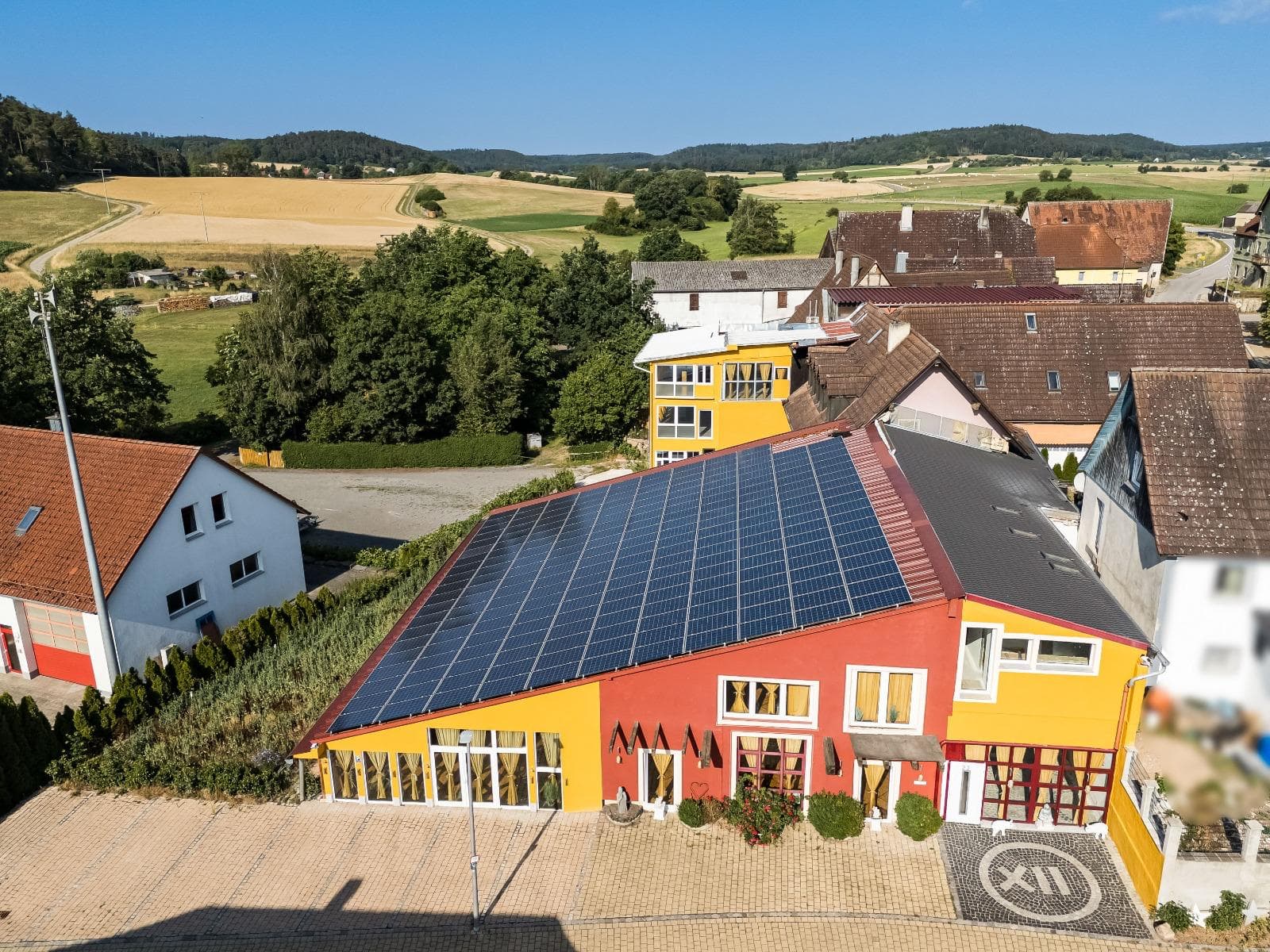 Aerial view of the red-and-yellow Punkt XII house with its solar roof