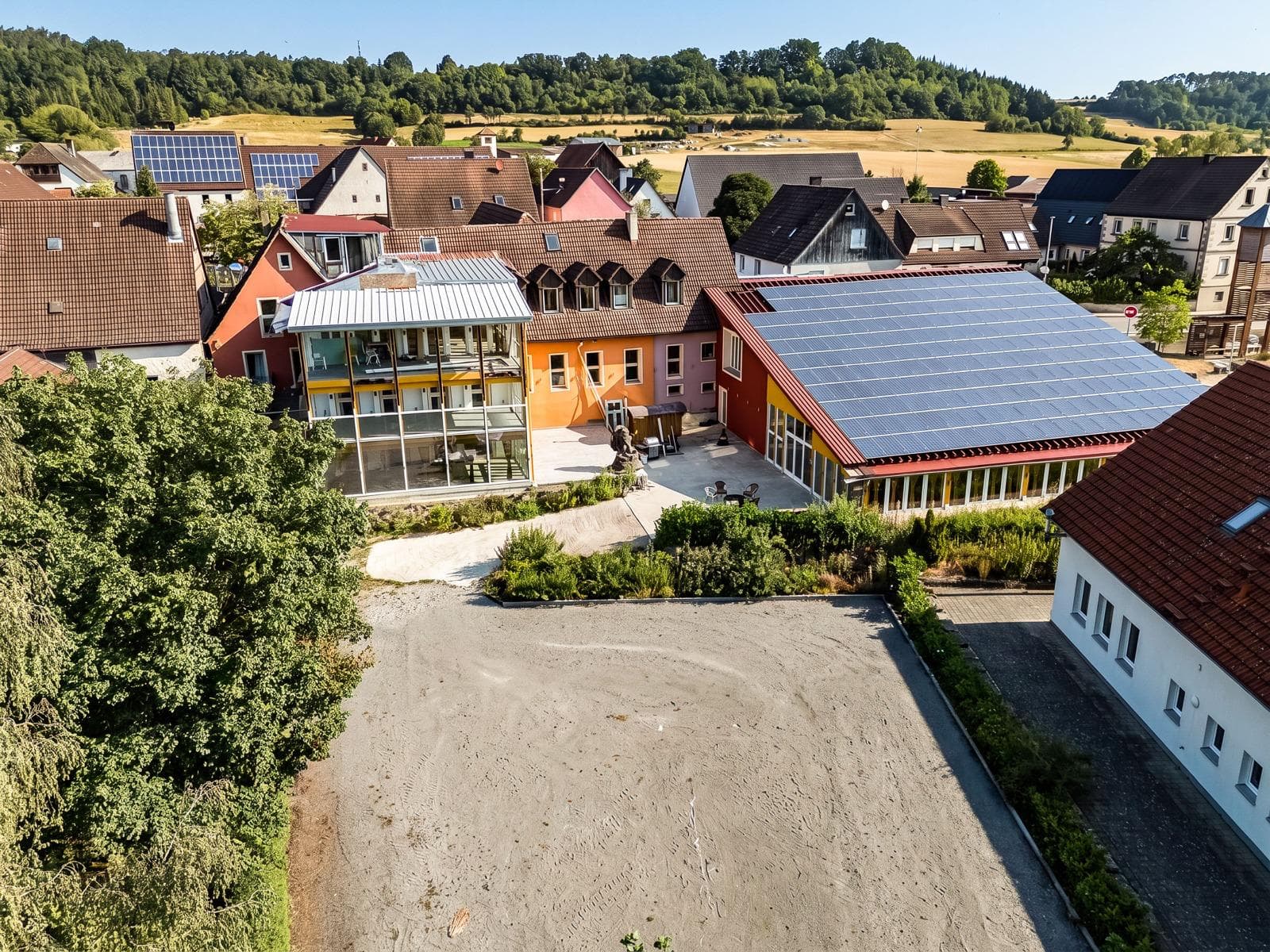 Aerial view of the whole Punkt XII grounds in the Steigerwald – glass winter garden, courtyard and the large solar hall