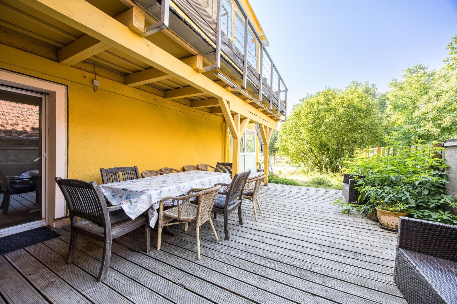 Sonnige Terrasse mit gedeckter Tafel und Blick ins Grüne