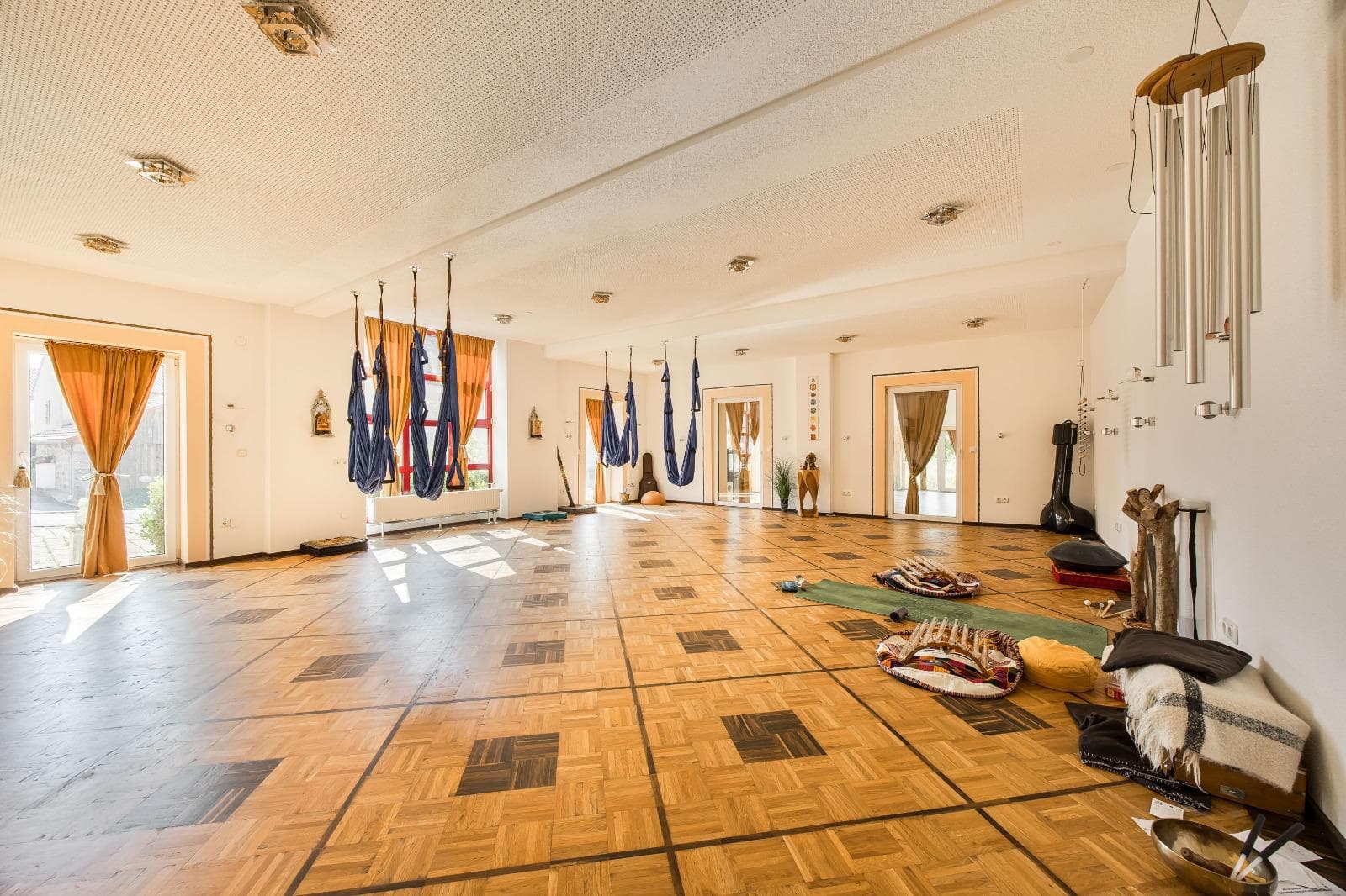Yoga hall with aerial-yoga hammocks and parquet floor