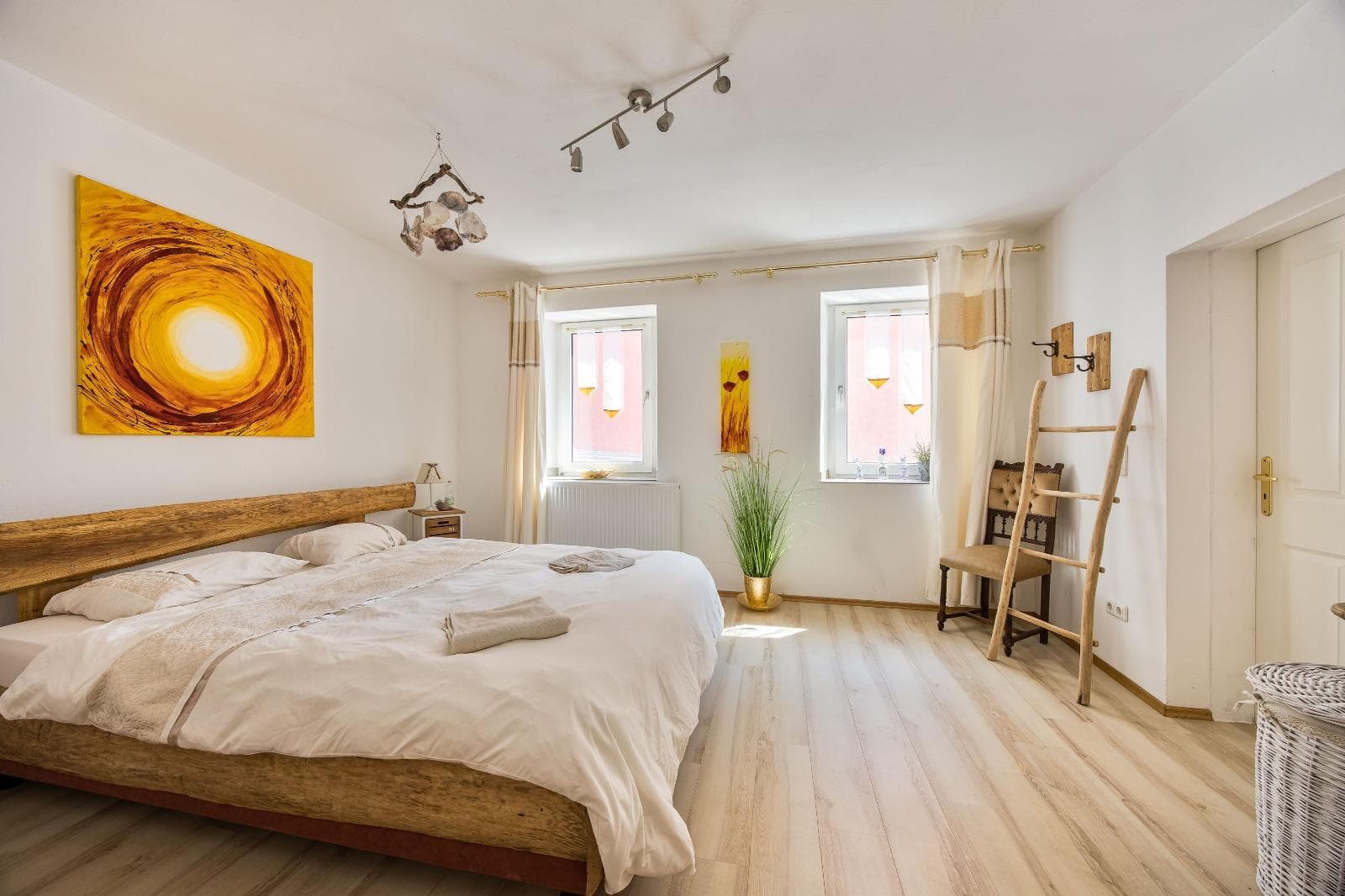 Helles Doppelzimmer mit Sonnenbild und Naturholz