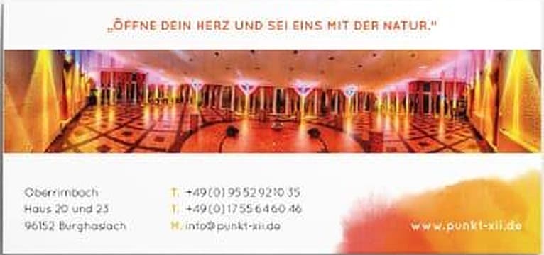 Rückseite der Visitenkarte von Punkt XII mit dem Leitsatz „Öffne dein Herz und sei eins mit der Natur.“, einem Foto des festlich beleuchteten Saals und den Kontaktdaten in Oberrimbach