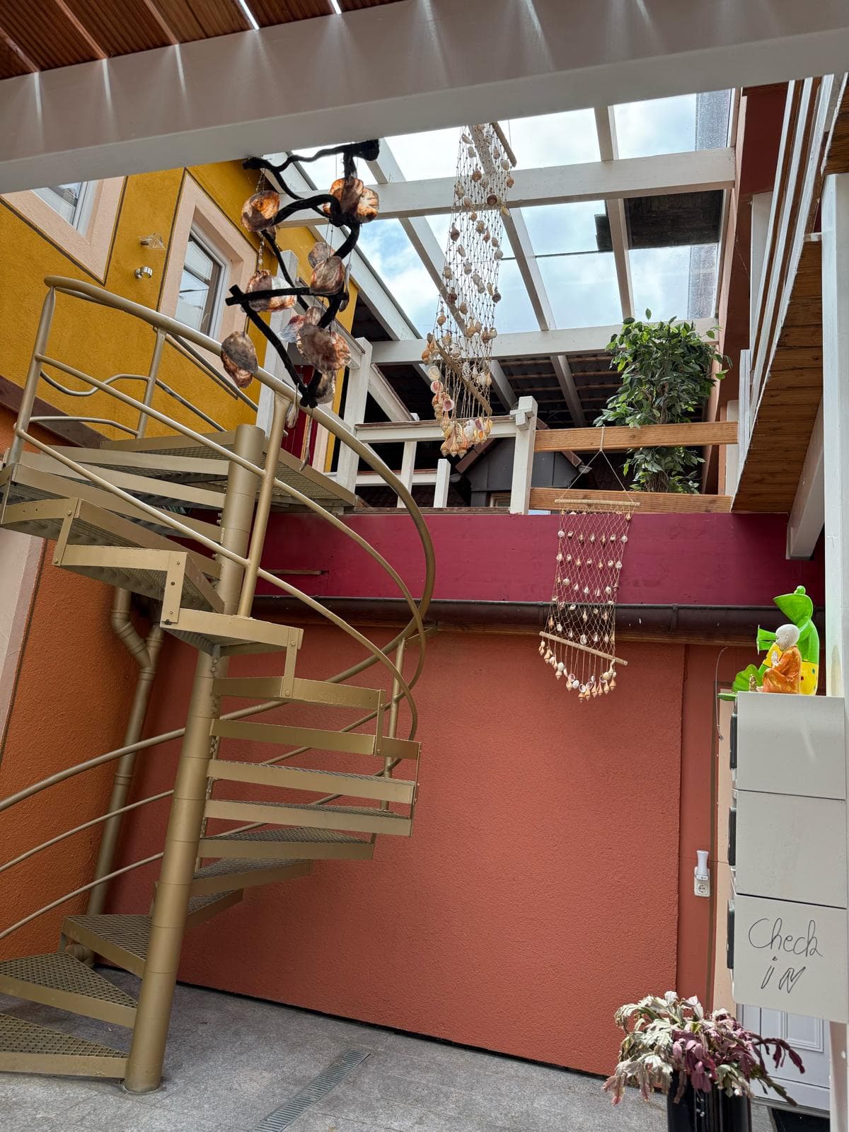 Wintergarten mit goldener Wendeltreppe und Glasdach